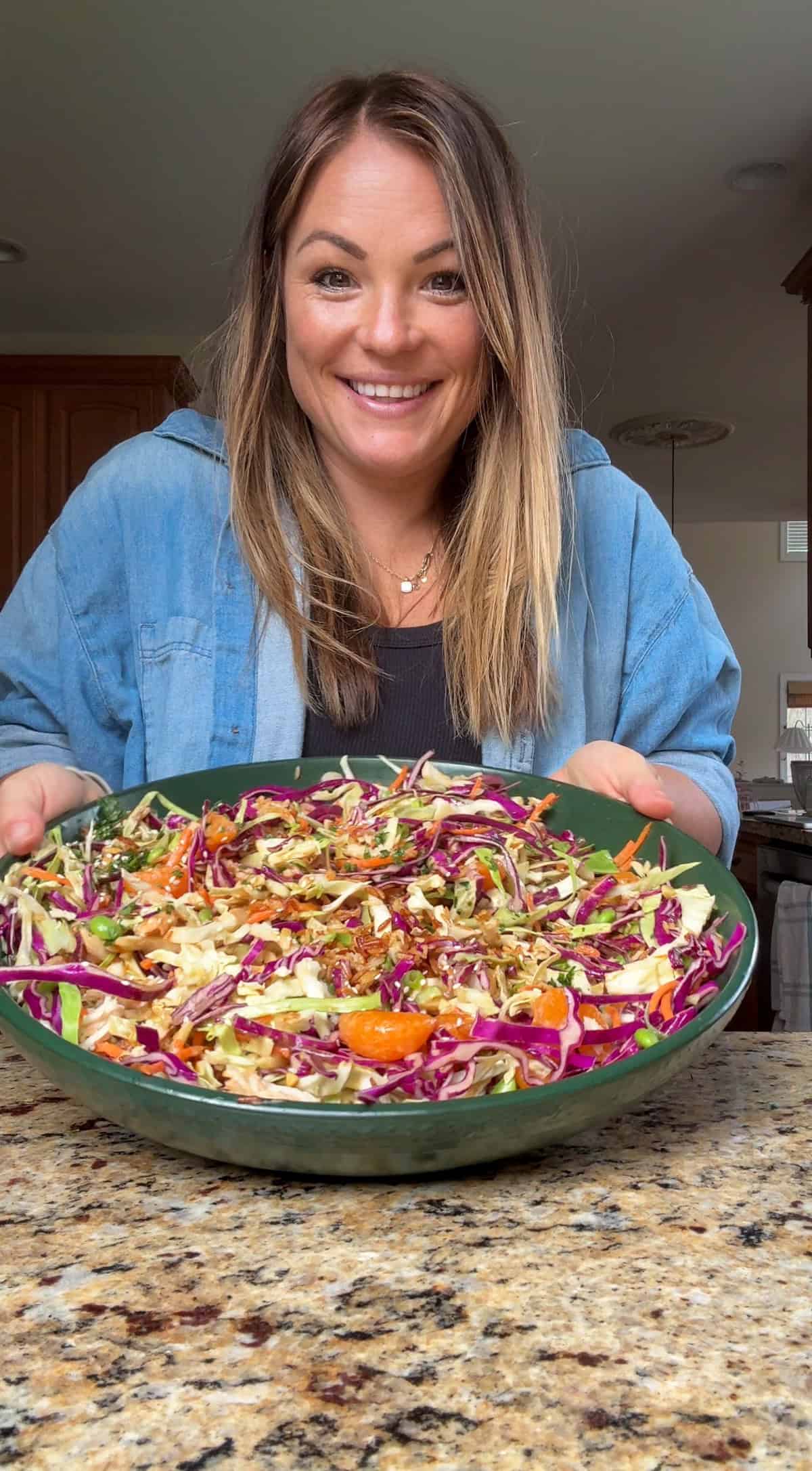 molly thompson from what molly made holding a bowl of mandarin orange chicken salad.