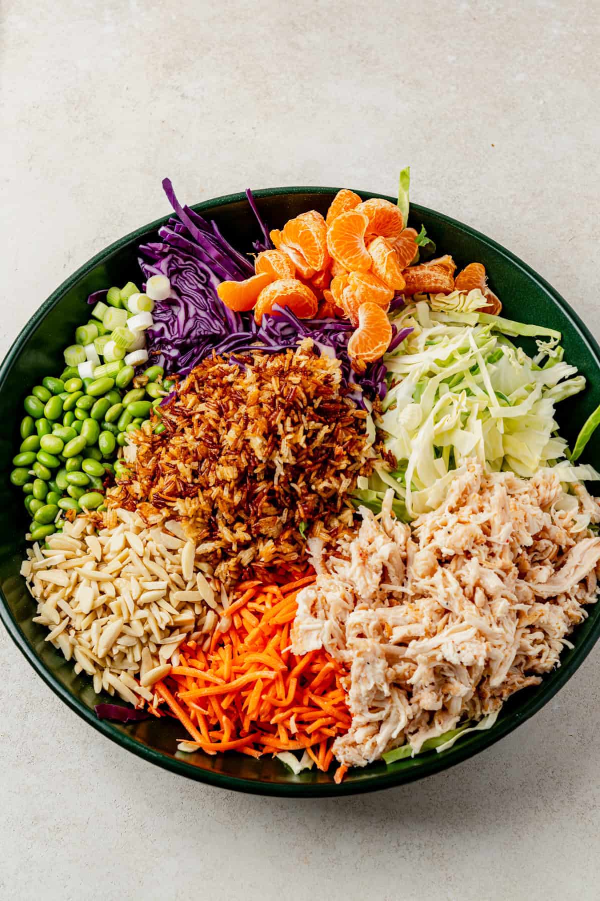 Mandarin orange chicken salad ingredients in a big bowl before dressing and tossing.