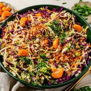 a big bowl of mandarin orange chicken salad topped with fresh cilantro and green onions.