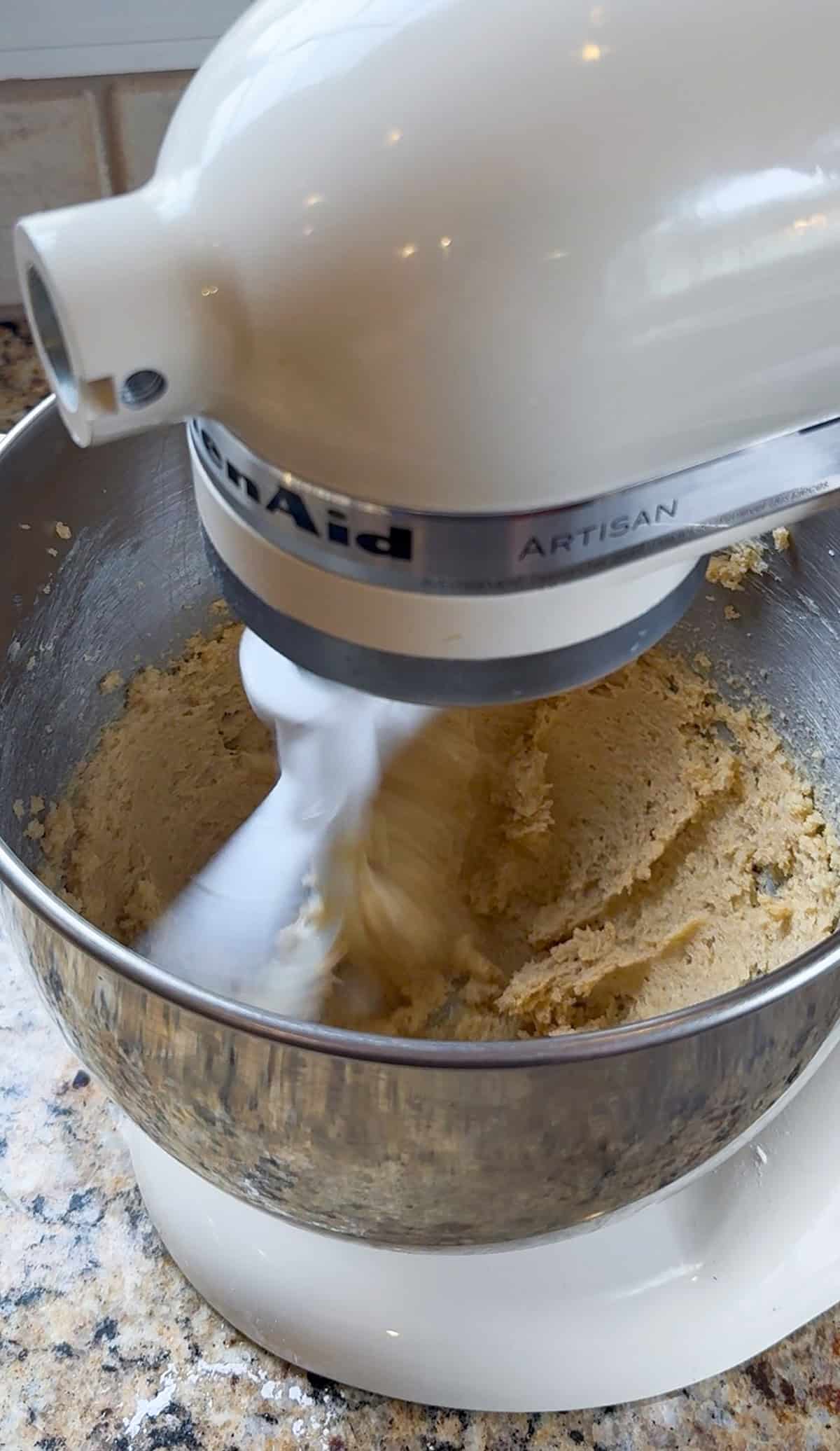beating butter and brown sugar in a white kitchenaid stand mixer.