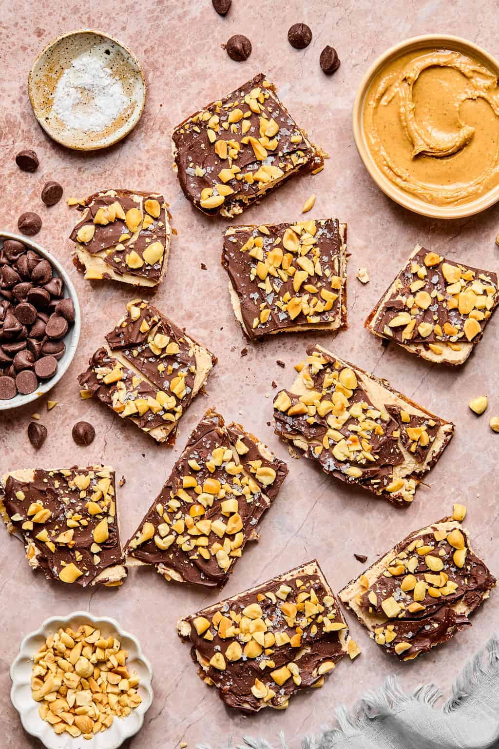 Delicious chocolate peanut butter bars topped with chopped nuts and chocolate chips.