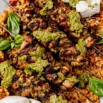Pesto grilled chicken skewers topped with pesto sauce, served over a bed of tomato orzo with fresh basil leaves and dollops of creamy white burrata.