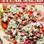 A platter of blue cheese and steak salad topped with cherry tomatoes, red onions, and creamy ranch dressing, with text: blue cheese & steak salad—30 min, steakhouse flavor at home.