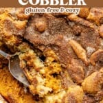 A close-up of a pumpkin snickerdoodle cobbler in a baking dish, with a spoon scooping out a warm serving of this irresistible pumpkin cobbler. Text overlay reads pumpkin snickerdoodle cobbler, gluten-free & cozy.