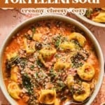 A bowl of creamy sausage and tortellini soup with cheese, savory sausage, greens, and tender tortellini in a rich tomato broth, topped with grated cheese.